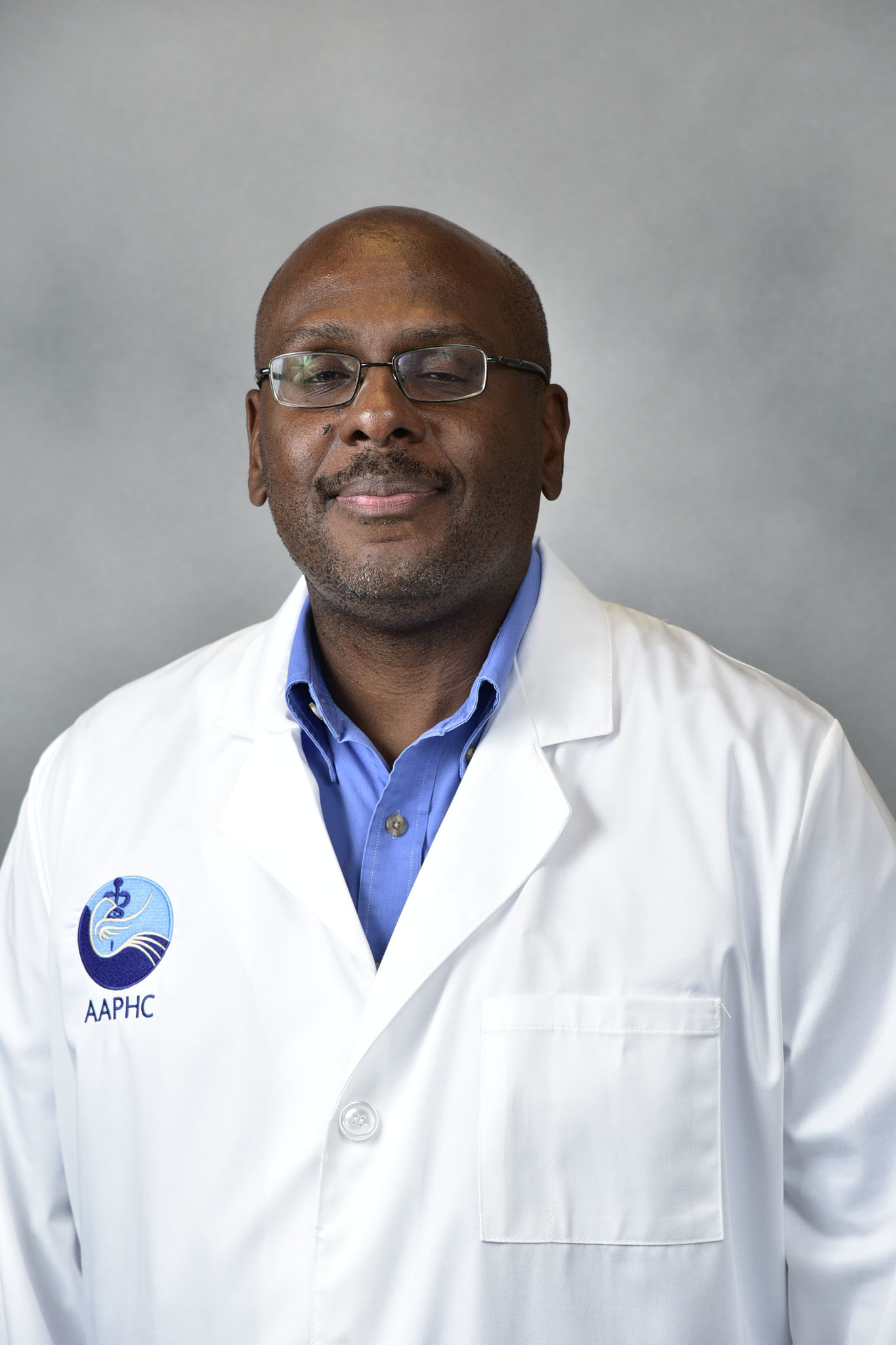 Dyer Rupert A man with a short beard, wearing a white lab coat and a collared shirt, looks at the camera against a plain, light background.