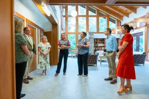 Seven adults stand in a semi-circle in a bright room, chatting during a Georgia Power Foundation community event.