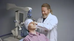 A doctor at Phoebe adjusts a medical cap on a patient during a brain scan for Behavioral Health Services.