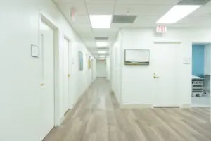Bright, clean hallway in a medical clinic for the Family Medicine Residency program, with artwork and an exam room on the right.