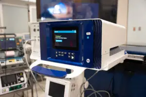 A close-up of a blue and white hospital device with a screen, highlighting advanced technology used in healthcare settings.