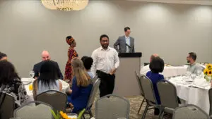 People seated at round tables as a speaker addresses Award Recipients and graduates from the Family Medicine Residency program at Phoebe.