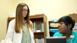 Dougherty County’s High Rate of Alzheimer’s Disease Highlights Urgent Need for Early Detection and Support 4 A doctor in Dougherty County discusses early detection of Alzheimer’s disease with a nurse seated at a desk.