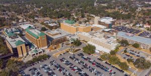 Aerial view of the Phoebe Hospitals complex in Georgia, with green rooftops, trees, parking lots, and nearby residential areas.