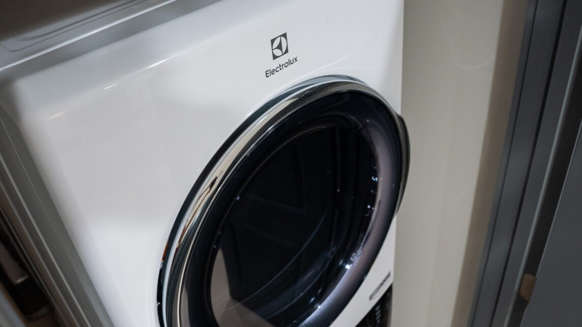 A white Electrolux front-loading washing machine with a black door, partially enclosed by walls on both sides—ideal for student housing or educational housing laundry rooms. A white Electrolux front-loading washing machine with a black door, partially enclosed by walls on both sides—ideal for student housing or educational housing laundry rooms.